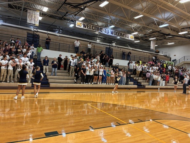 Students sit in the stands in the gym during the pep rally