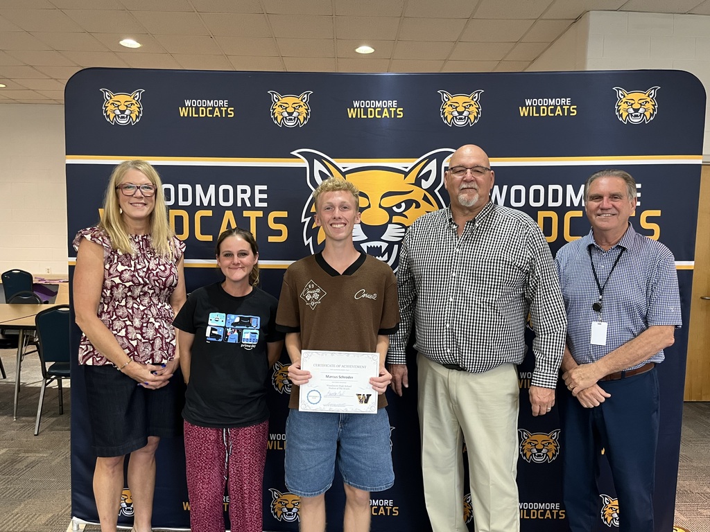 September High School Student of the Month, Marcus Schroder, with family and district representatives in front of the Woodmore backdrop.