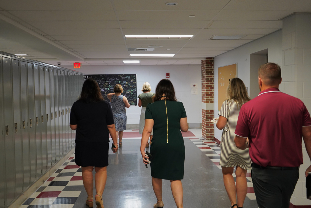 People walking down hallway