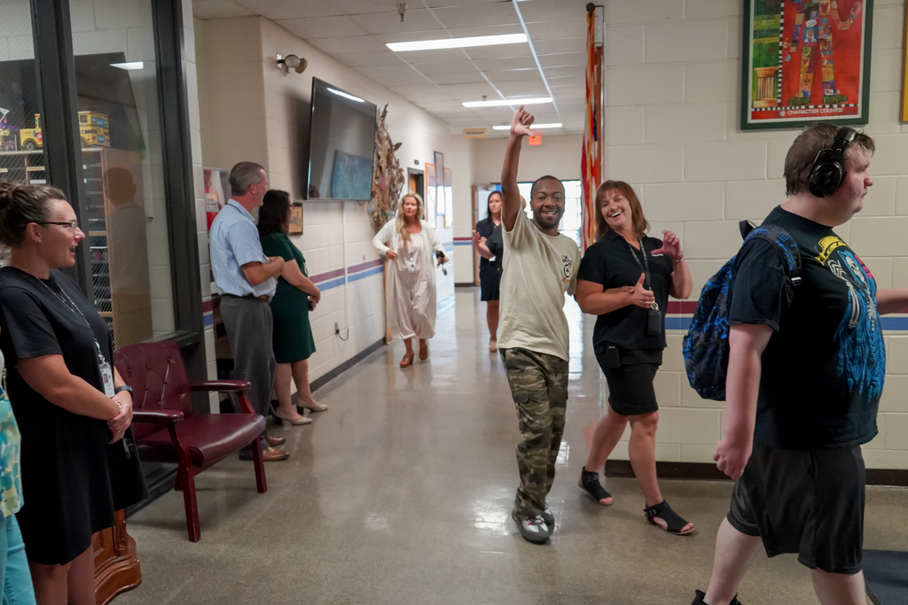 People in a hallway, waving