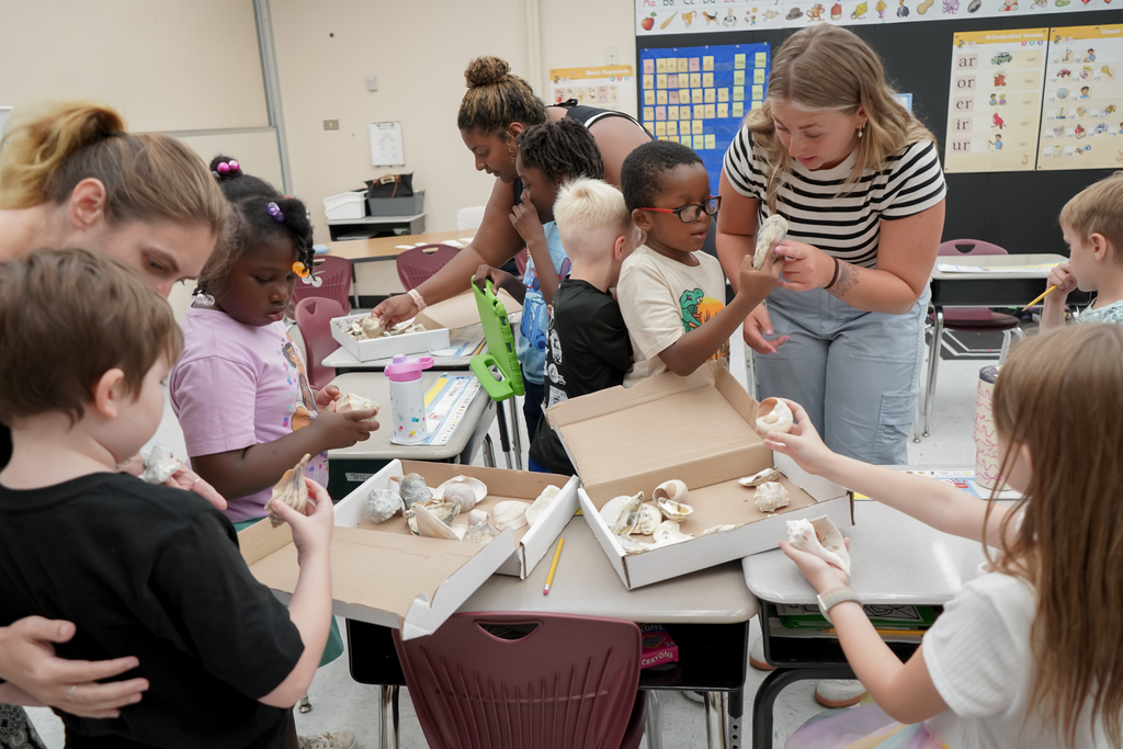 Students holding seashells