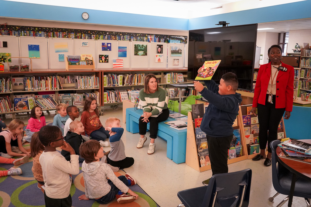 Student showing off new book to class