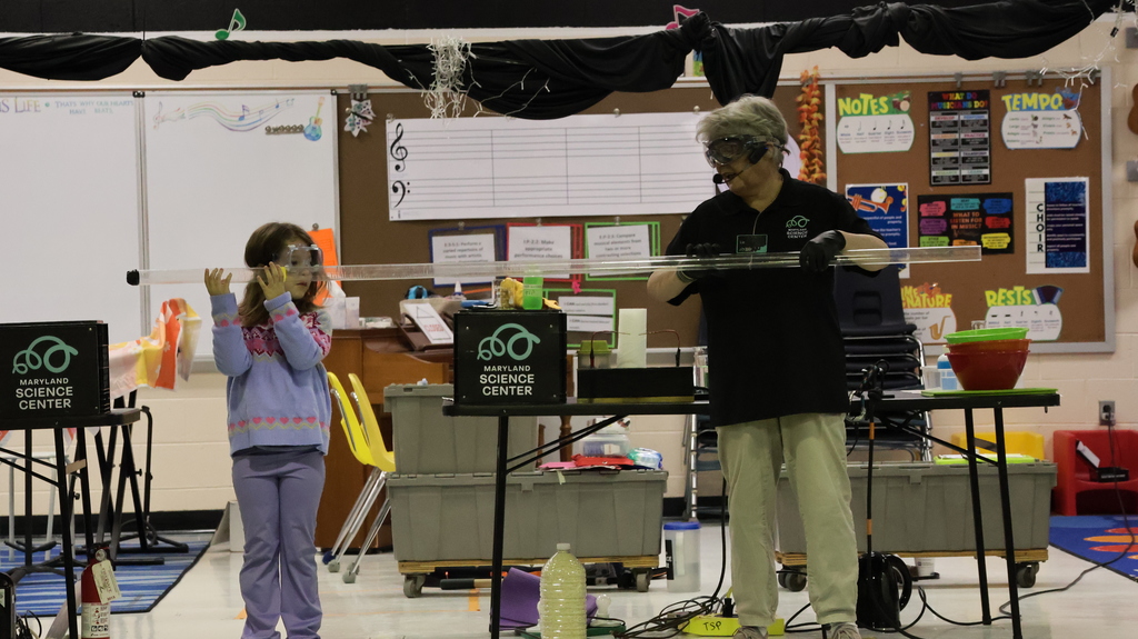 student and staff on stage holding sound tube