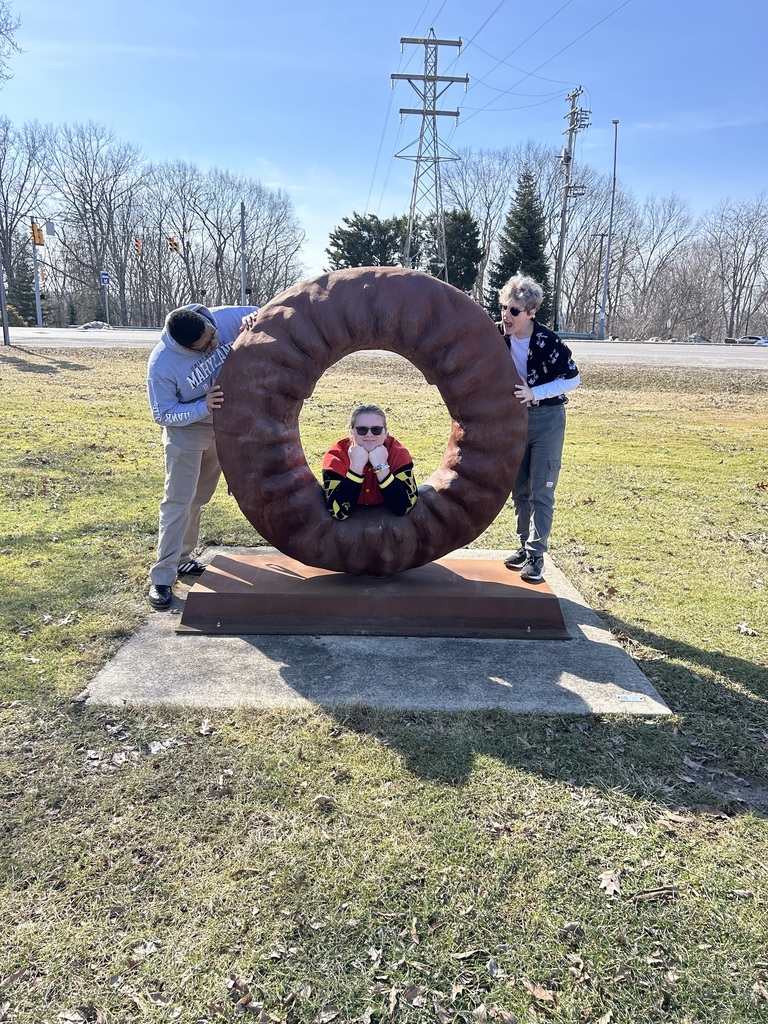 Myles, Alex, and Oliver posing by the doughnut