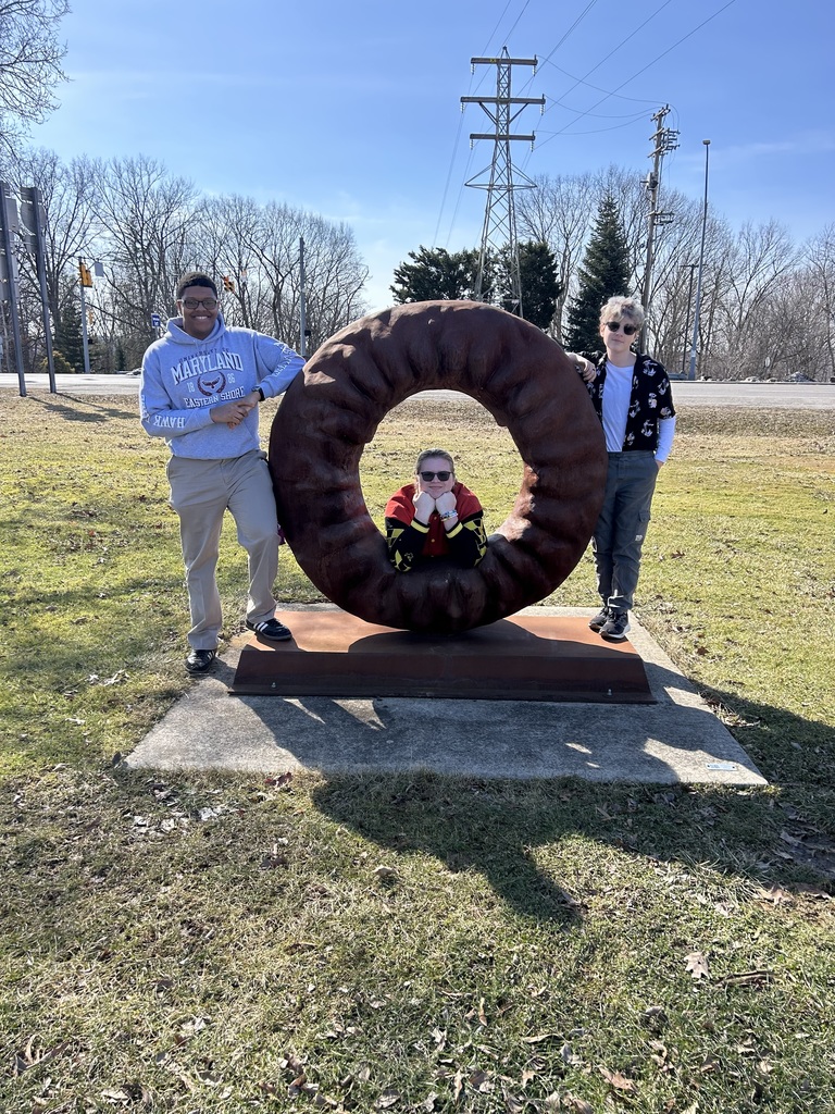 Myles, Alex, and Oliver posing by the doughnut