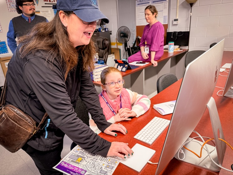 woman works with student on computer