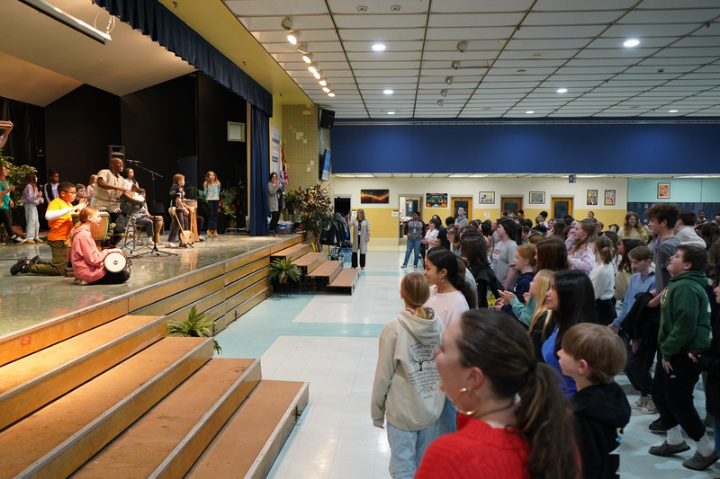 Ssuuna on stage with Berlin Intermediate students with assembly dancing