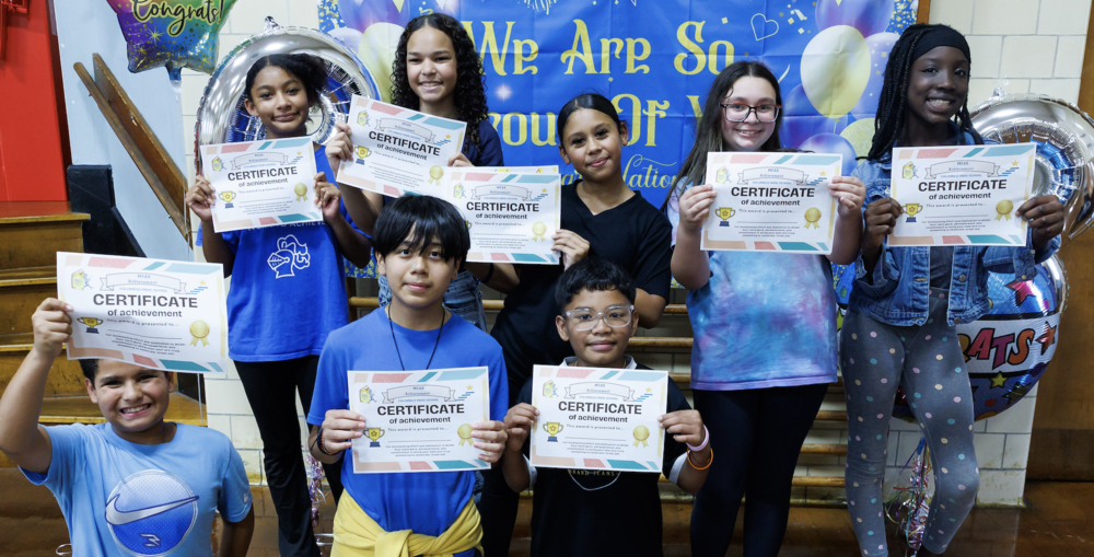 Eight students holding certificates of achievement