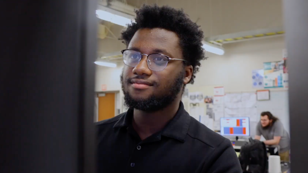 Joel Kimani works at at a computer.