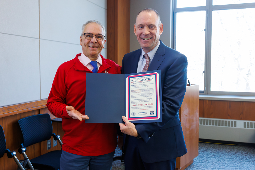 Two adults stand side-by-side holding an official decleration.
