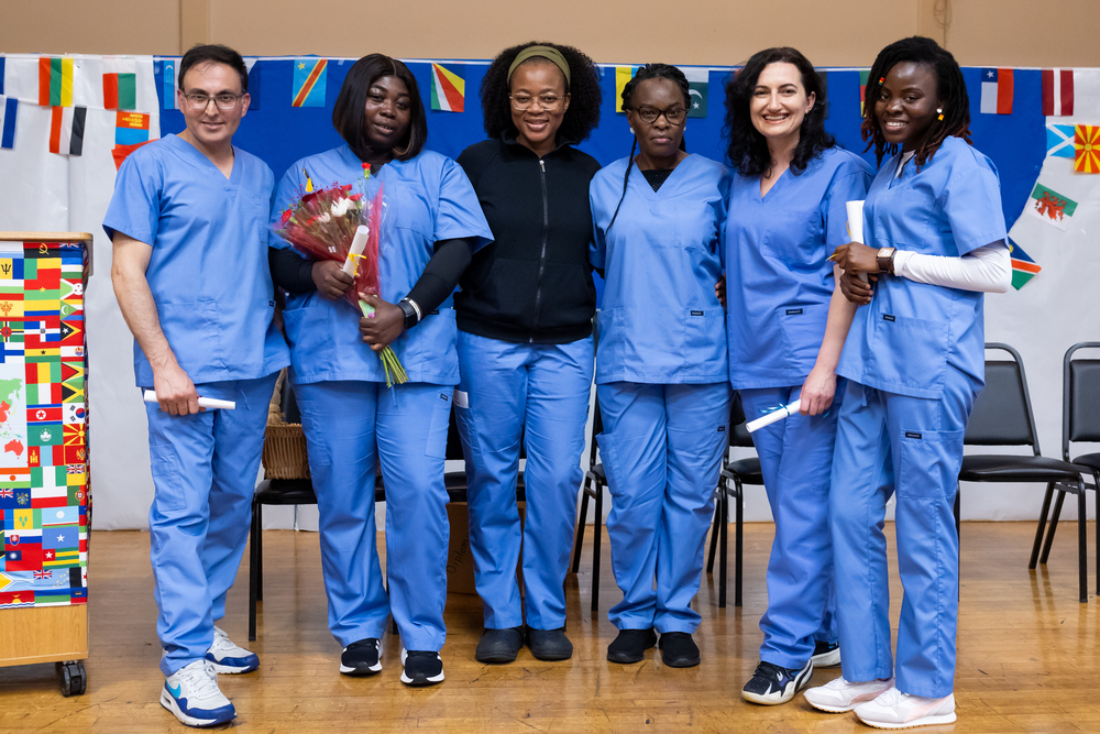 Six adults wearing nursing scrubs