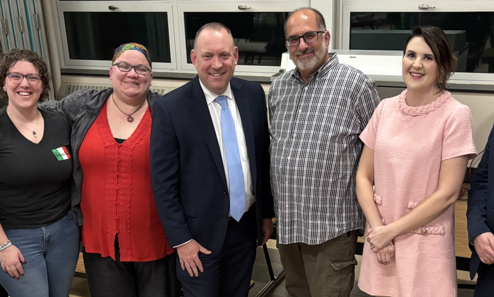 Five adults smiling for a photo with Brian Allen in the center