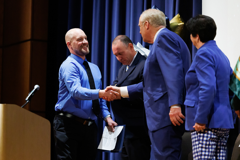 Drew Weymouth shakes hands with Mayor Joseph M. Petty after accepting the Principal of the Year award.