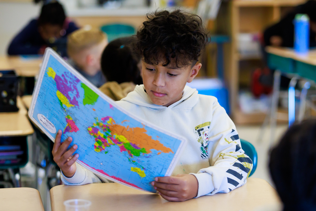 A student examines a world map.