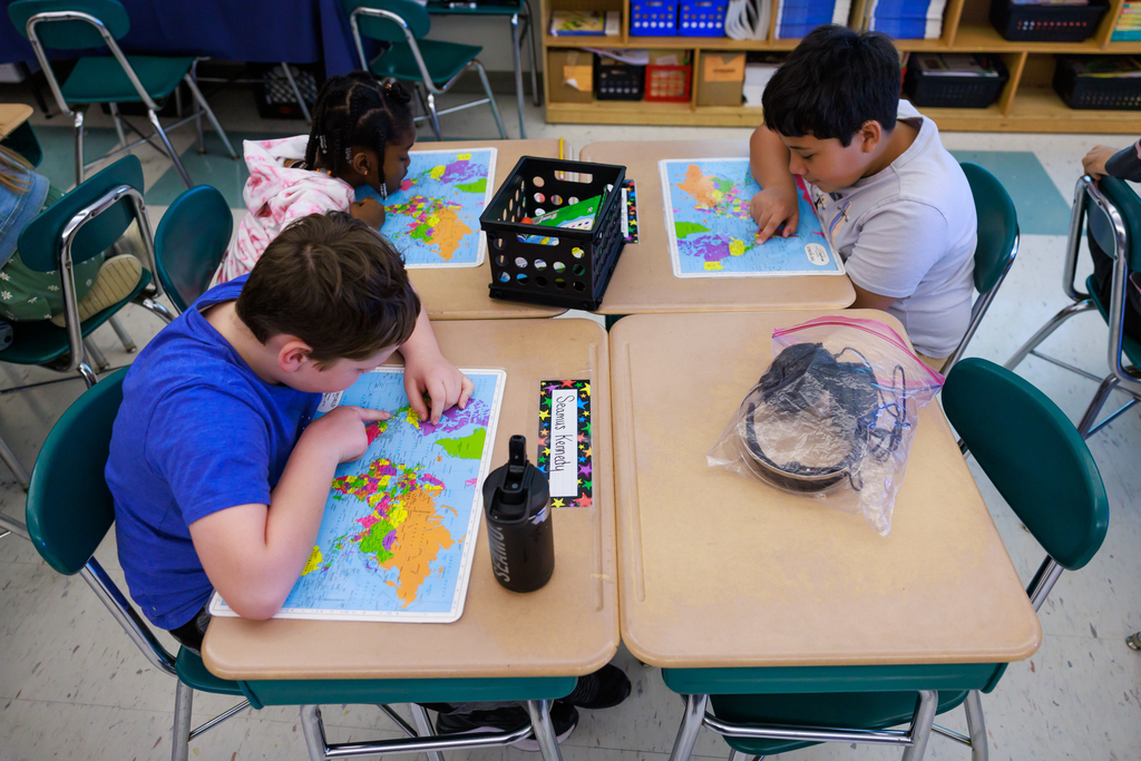 A students examine a world map.