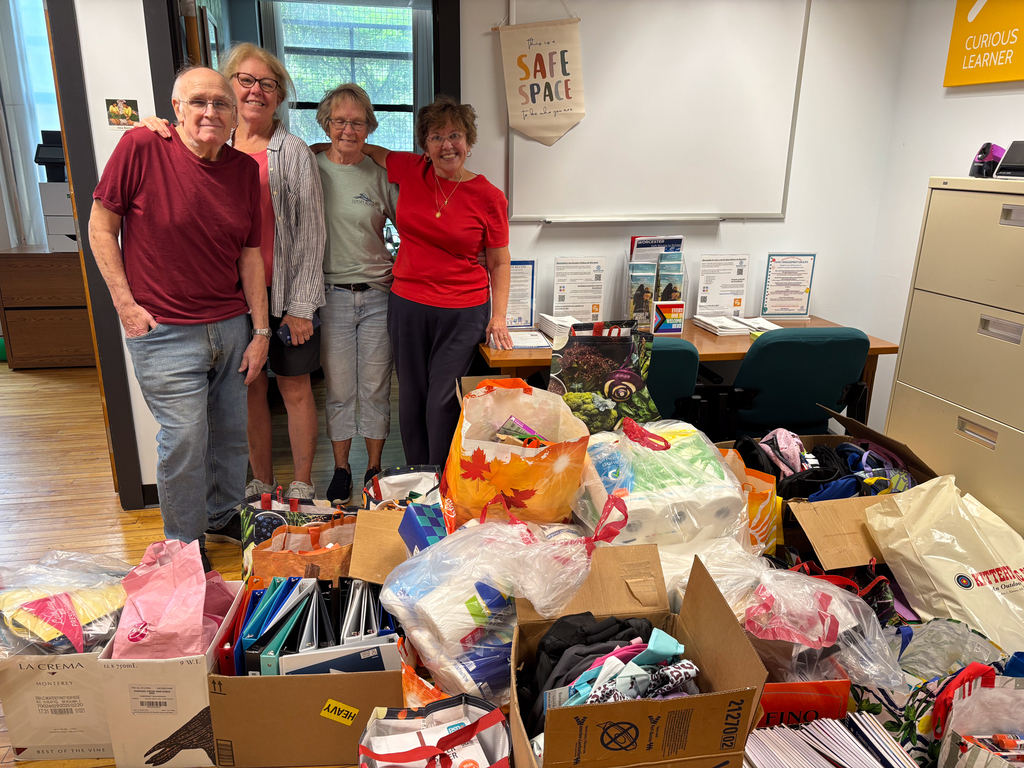 Four representatives from St. Mary's Church stand behind a pile of donated school supplies.
