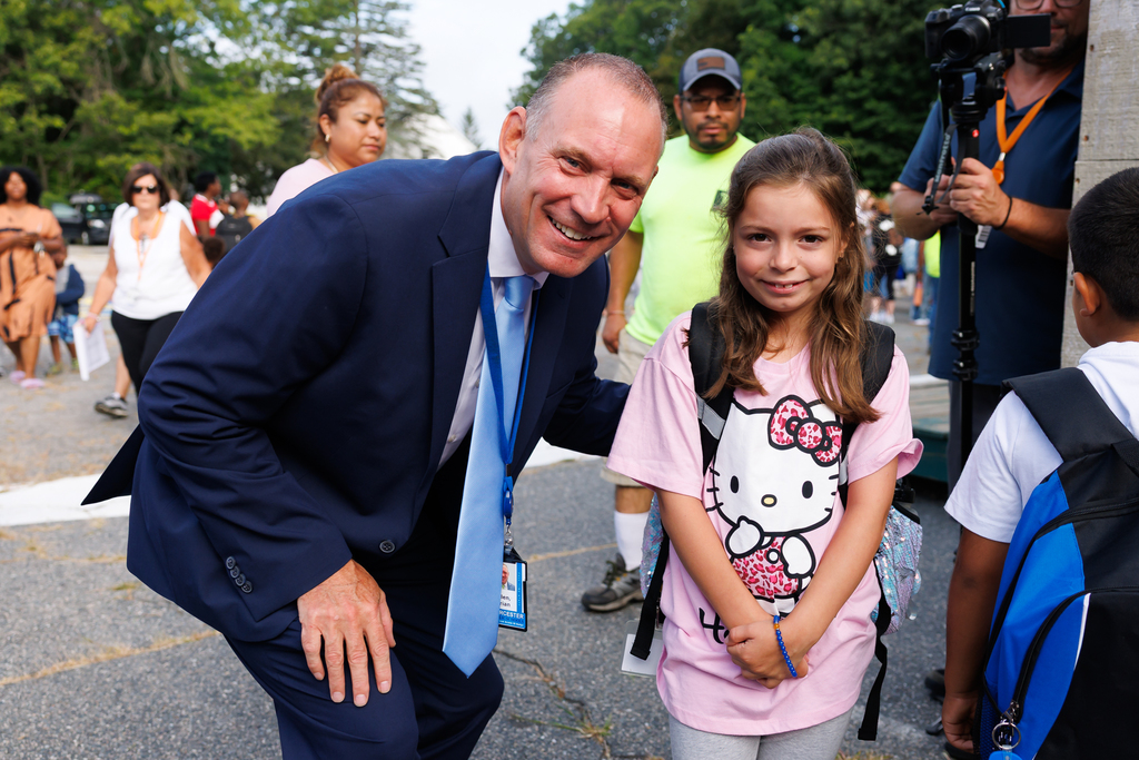 Superintendent Allen smiles for a photo alongside a young student wearing a Hello Kitty shirt.