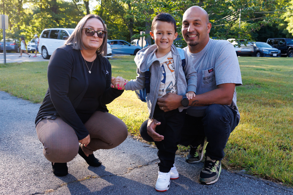 A family of three take a photo together on the first day of Pre-K.
