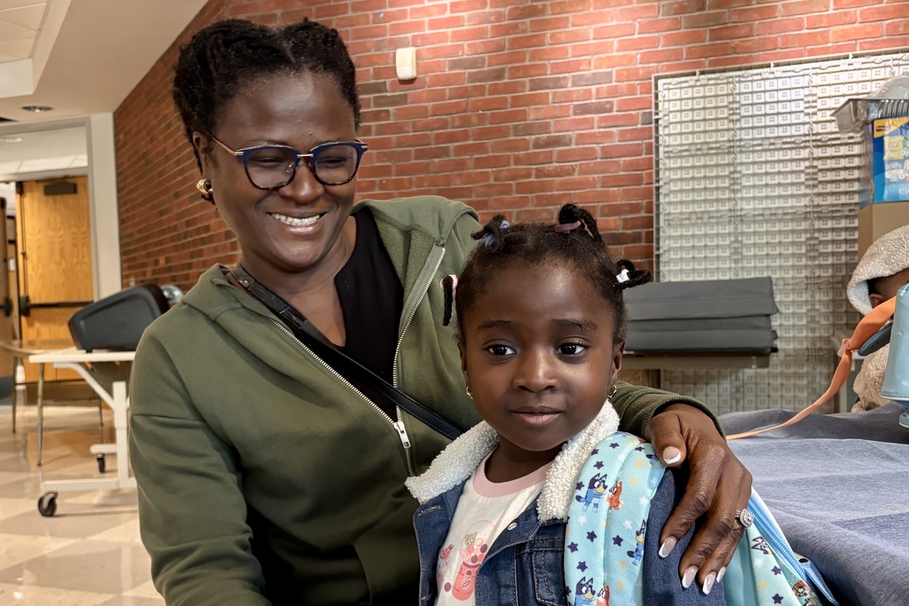 A mom looks at their child and smiles during the first day of Pre-K and Kindergarten.