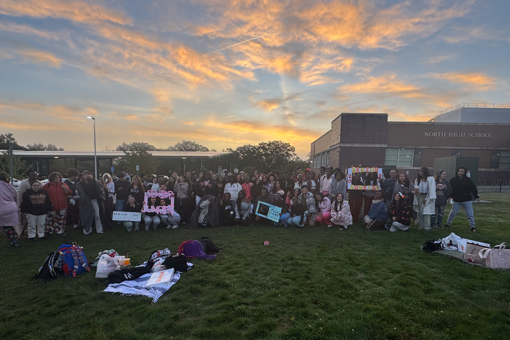 North High School seniors take a photo in front of a colorful sunrise.
