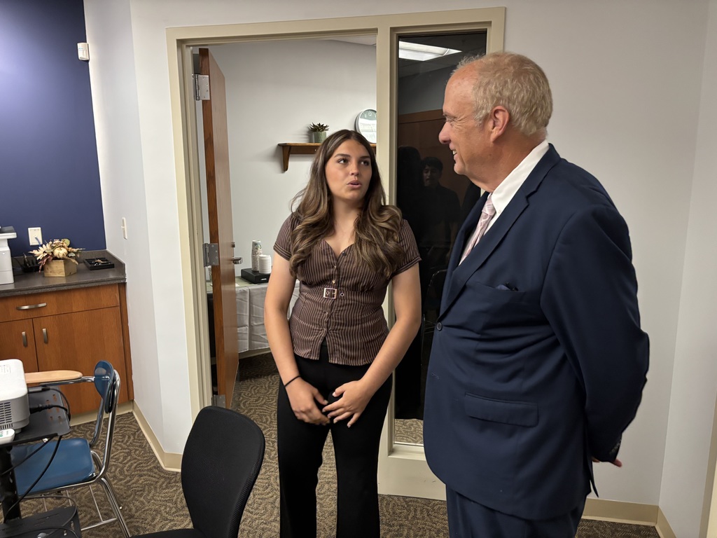A student gives a tour of the credit union to Mayor Joseph Petty