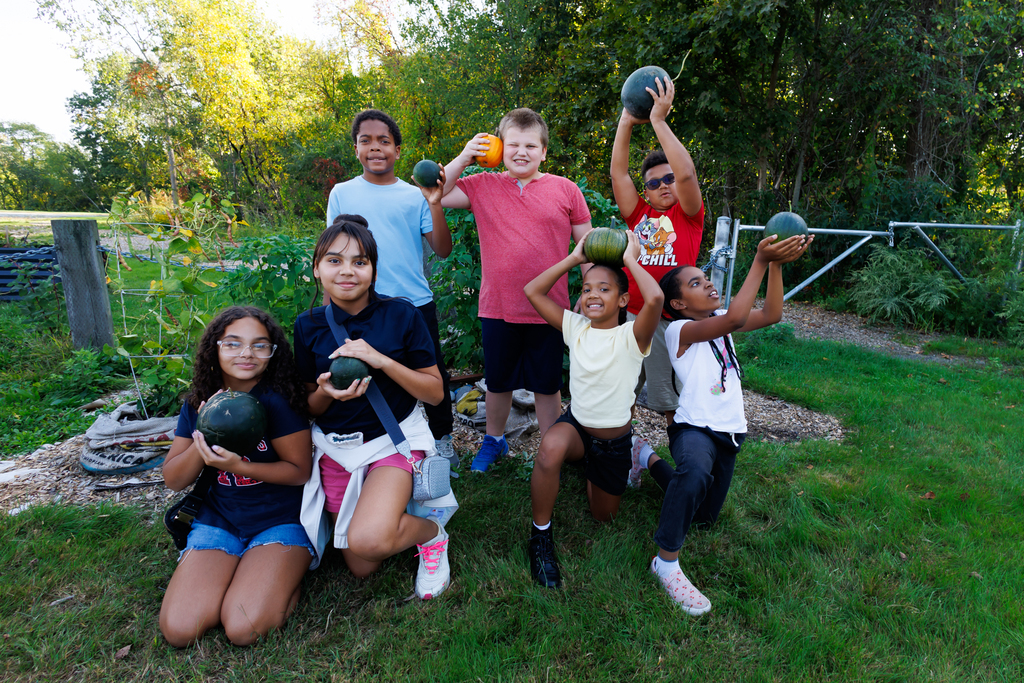 Seven students hold up their freshly harvested produce.