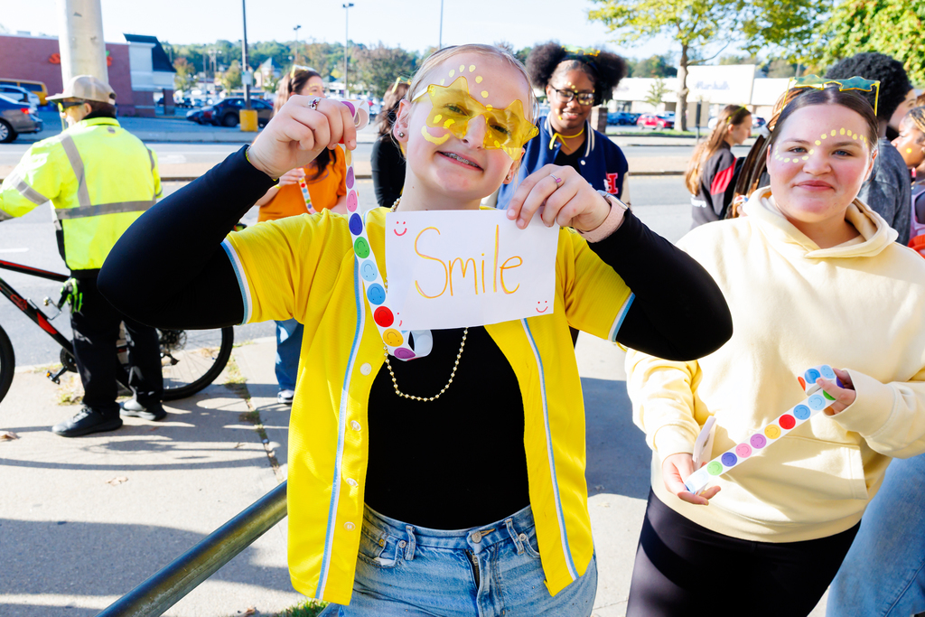 A South High student holds up a sign that says "Smile".