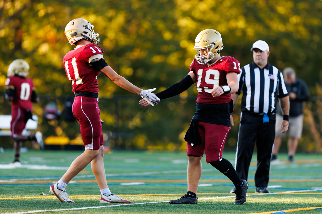 Two players high-five during a football game.