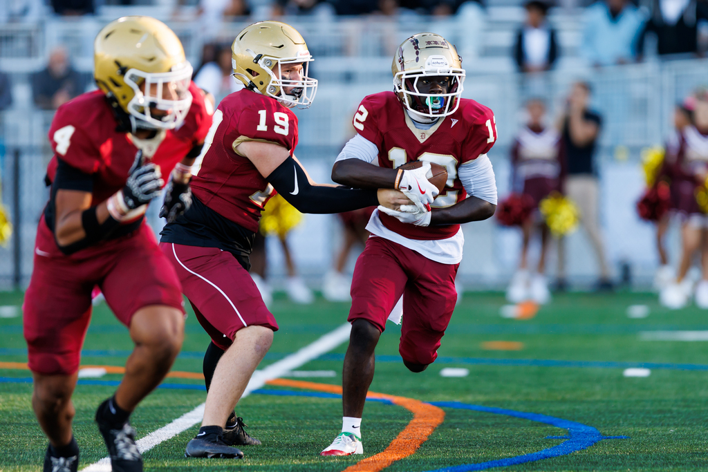 A player takes the handoff from the quarterback during a football game.