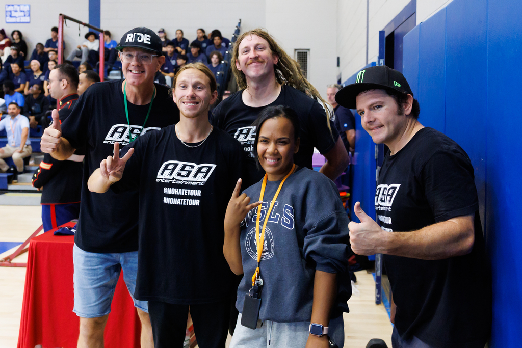 A staff member stands with four BMX bike riders during an event at Worcester Tech.