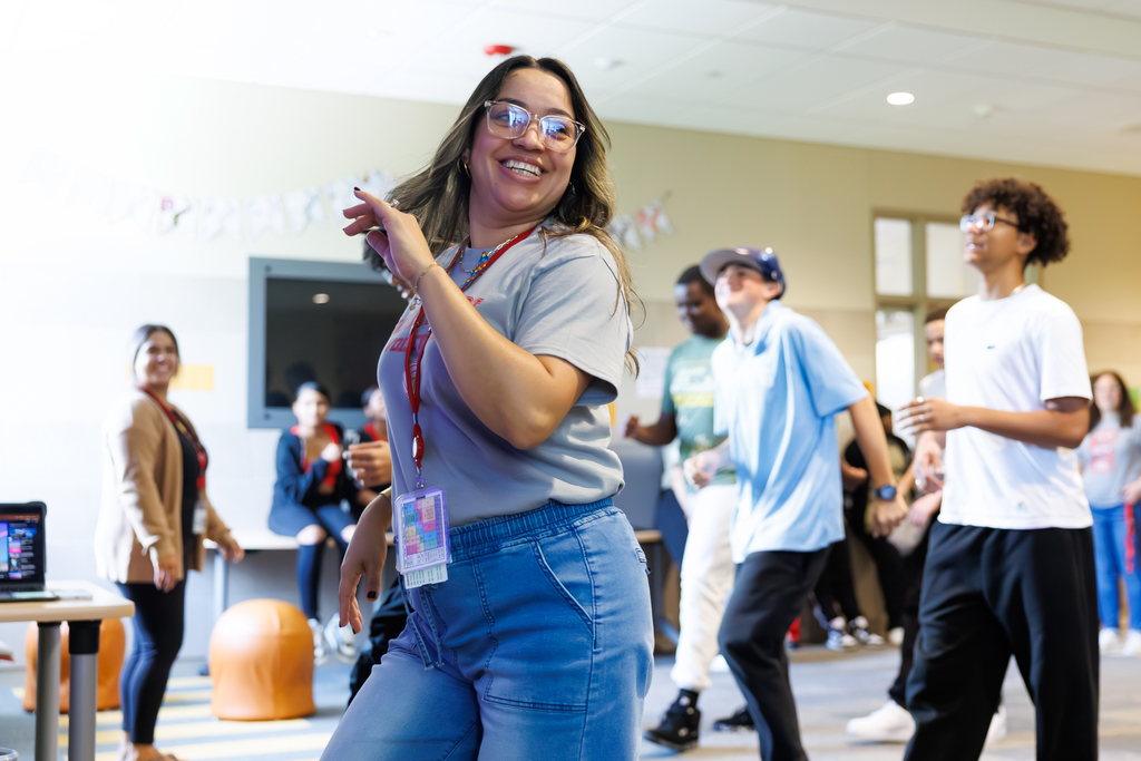 A teacher leads students in a dance lesson.