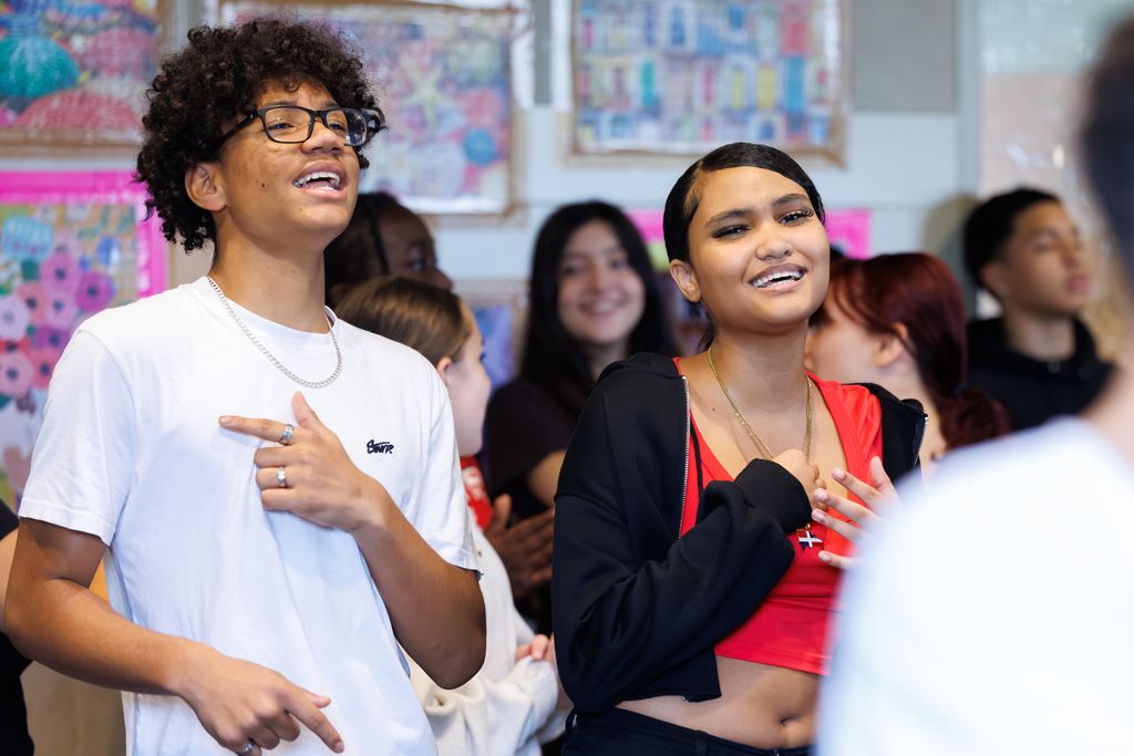Two students sing and dance during a lesson.