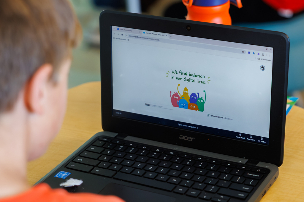 A laptop screen with an image that says "We find balance in our digital lives"