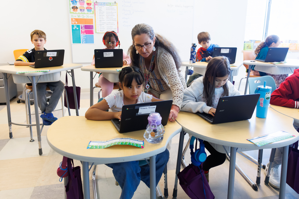 A teacher assists a student during a lesson.