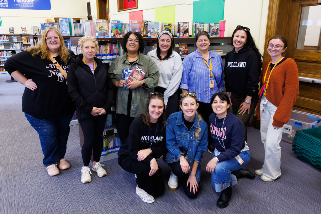 Ten staff members from Woodland Academy smile together for a photo.