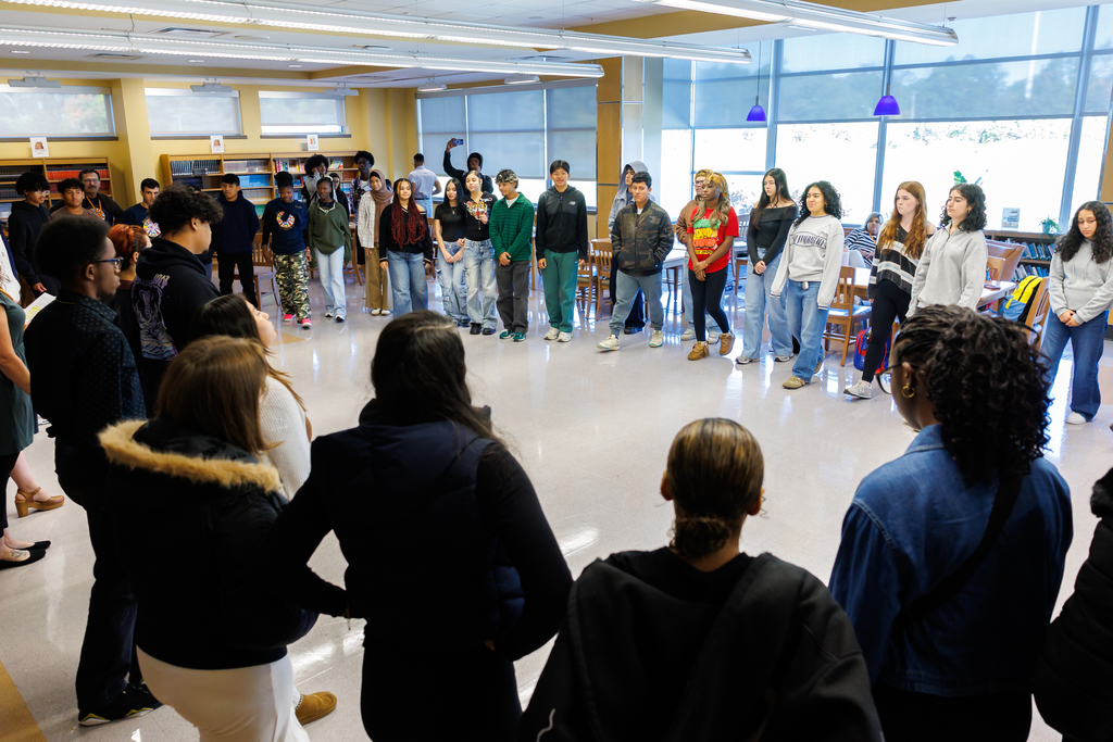 A room of students participate in a "step-in" activity.