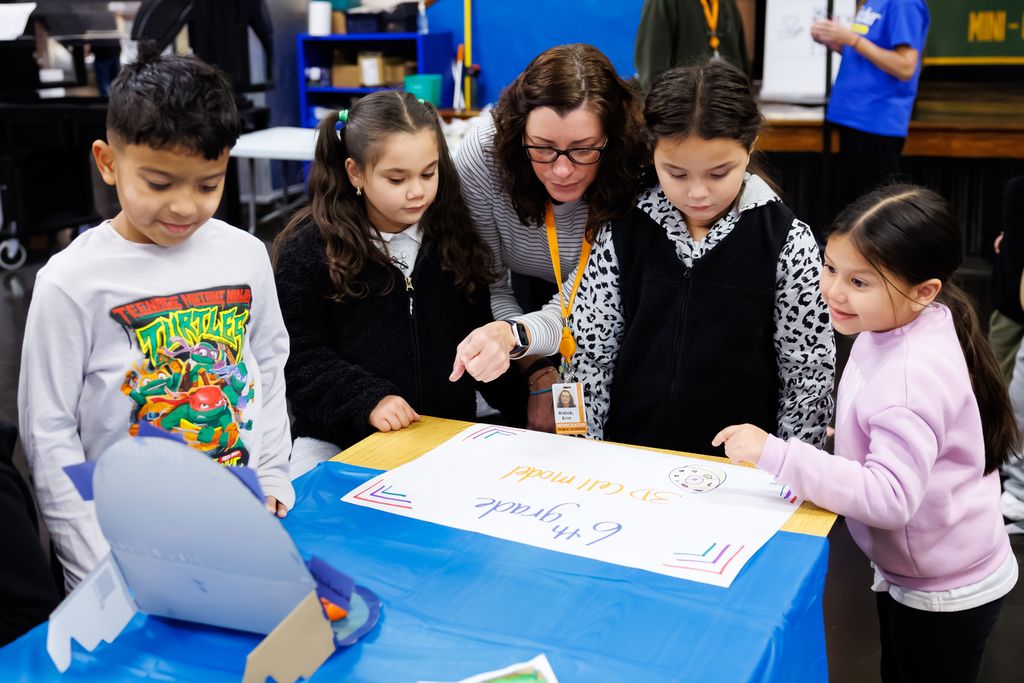 Four students and a staff member engage in a project during a STEAM Showcase at Lake View.
