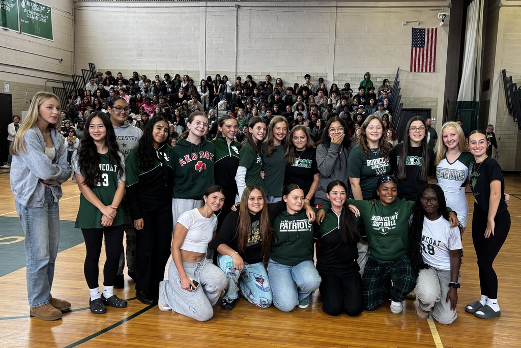 A diverse group of students pose together in a school gymnasium.