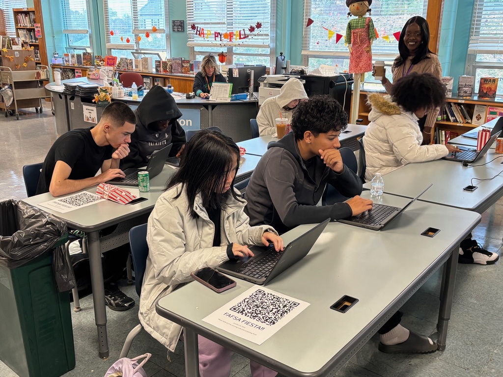 A group of students work on FAFSA applications during a school event.