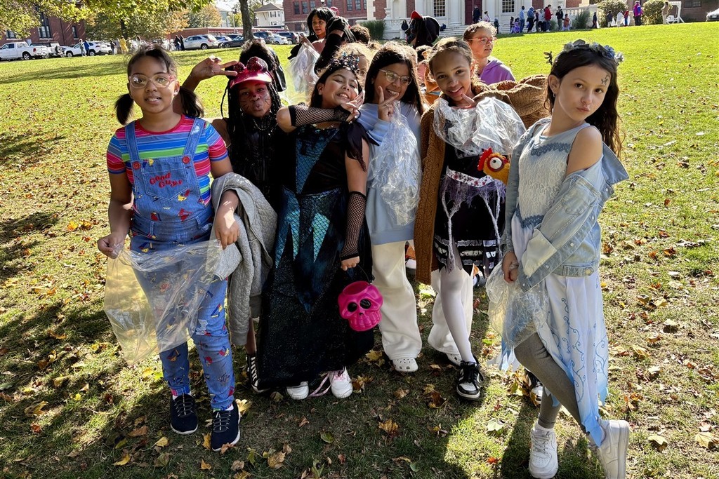 Two people dressed as Spider-Man pose for a photo outdoors.