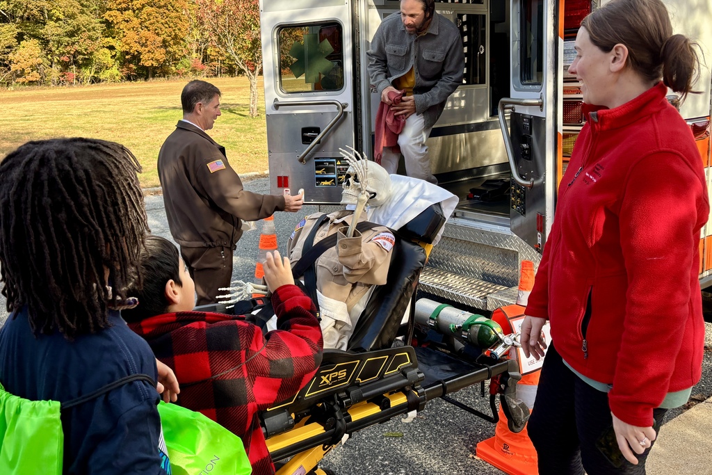 People gather near an ambulance, possibly at an event or demonstration.