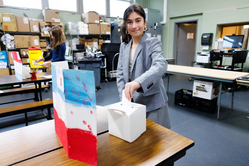 A student casts their vote for sixth grade elections.