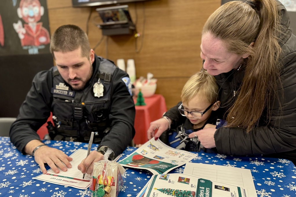 A police officer helps a family with a Christmas gift list.