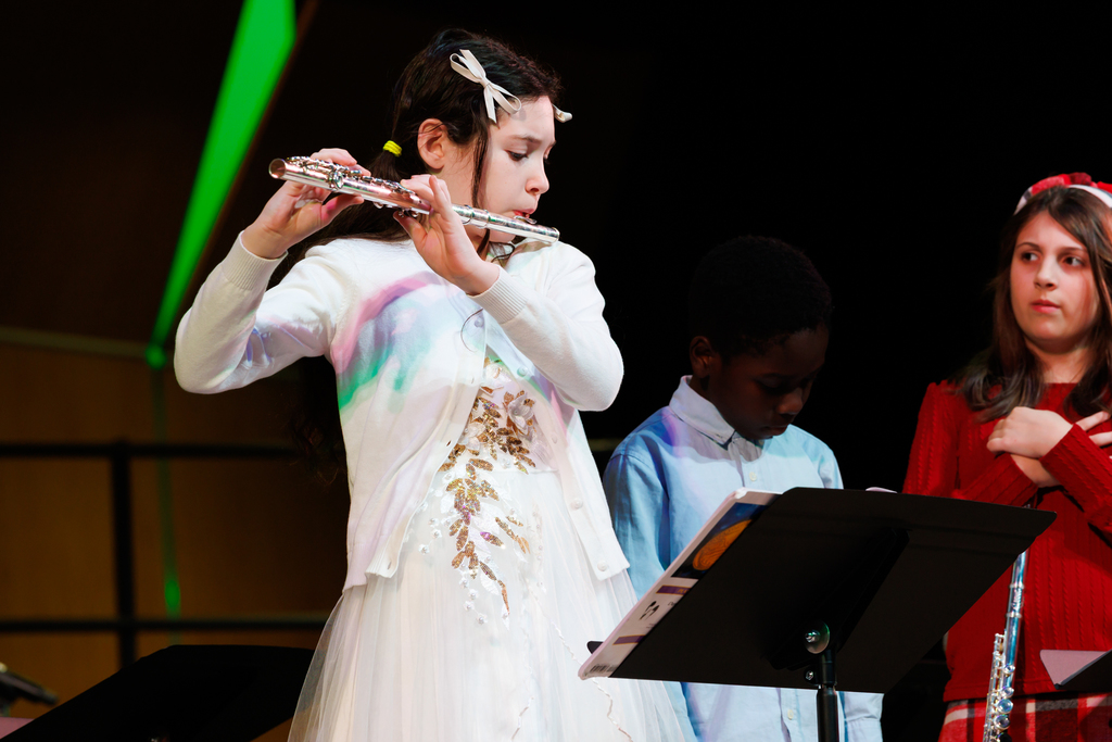 A young student plays a flute solo during a holiday concert.