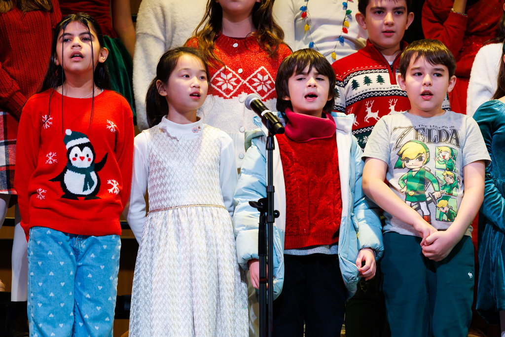 Four young students sing during a holiday concert.