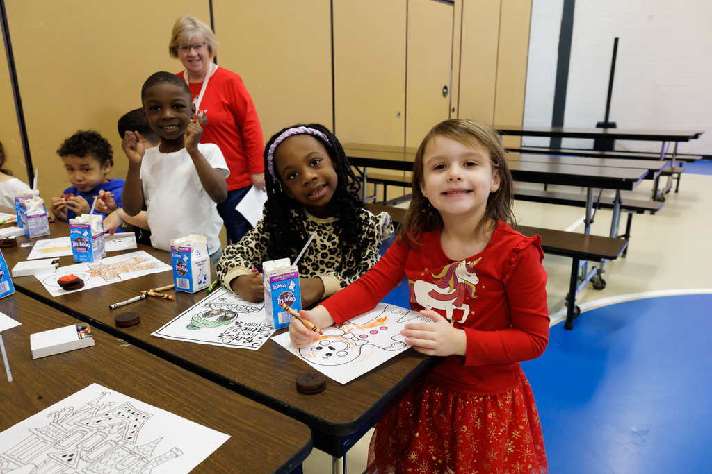 Students color at lunch tables.