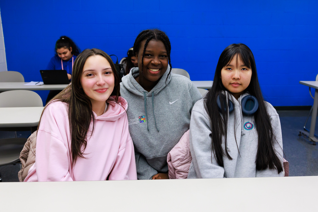 Three students smile for a photo during the first class of the WPS Grow Your Own Program.