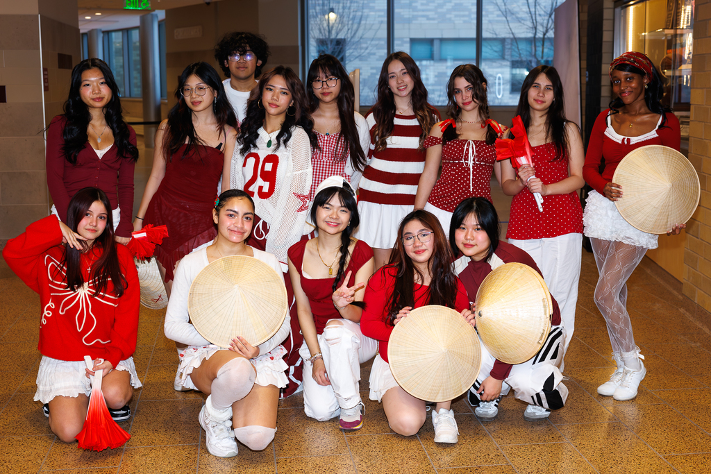 A group of students smile for a photo together in the school hallway.