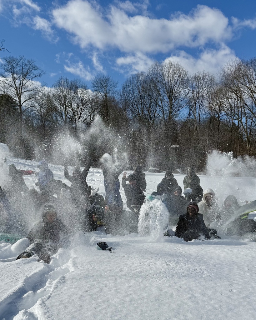 Students throw snow to the sky during an outdoor science experiment.