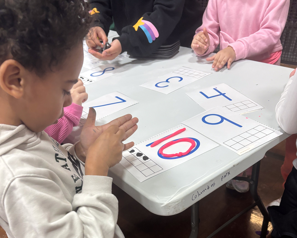 A student works on a math project with the numbers 10, 9, 4, 7 and 3 visible.